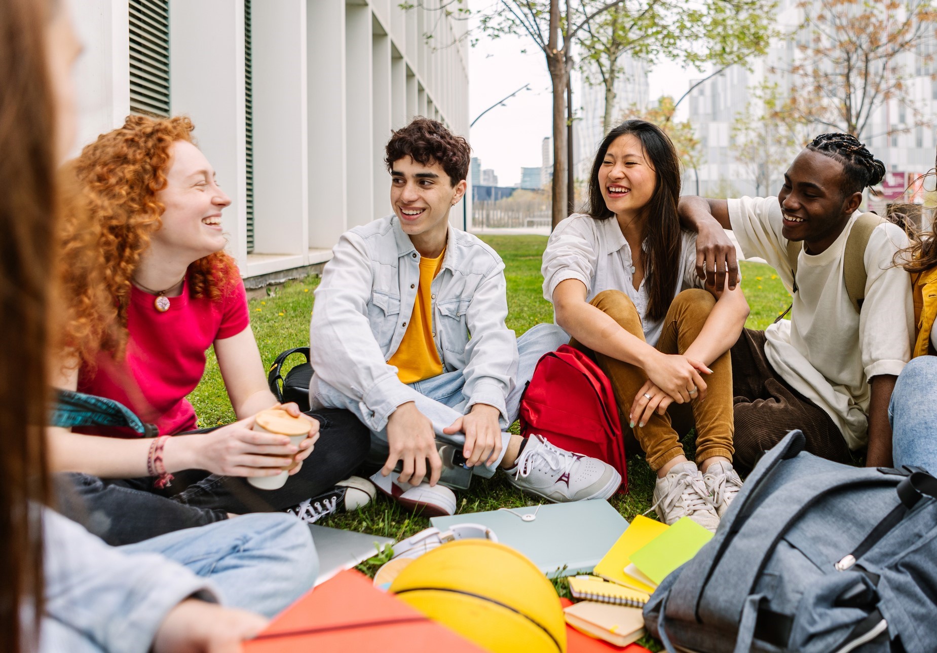 Students sitting outside on campus laughing